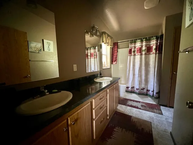 a bathroom with double vanity and a mirror