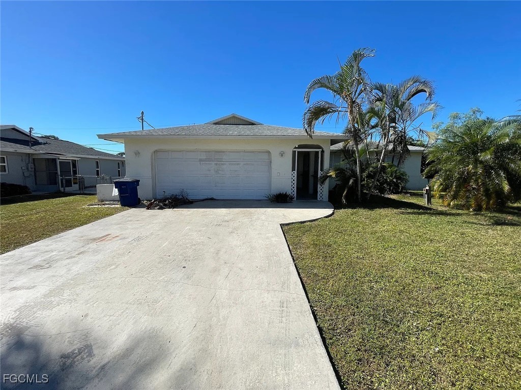 a view of a house with a yard and a garage
