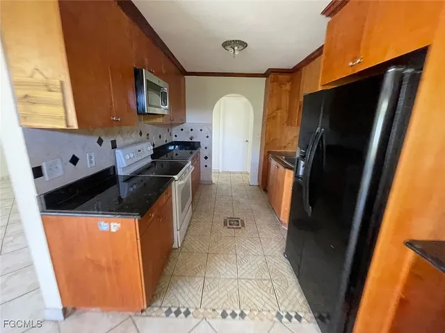 a kitchen with stainless steel appliances granite countertop a refrigerator a stove and a sink