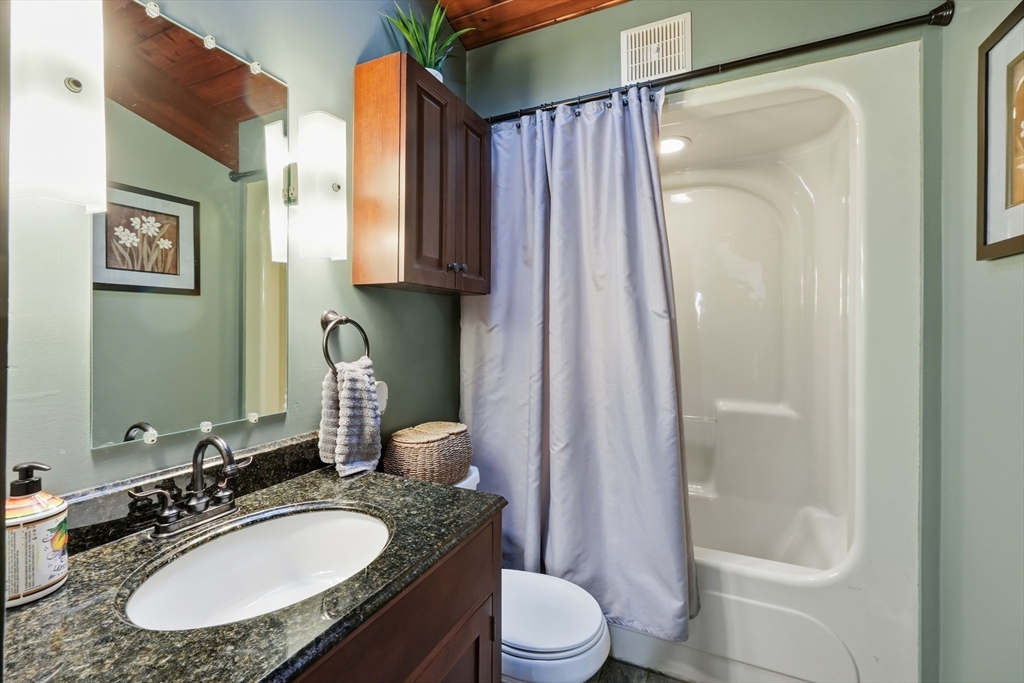 1023 North Woodstock Road Southbridge, MA 01550 - Photo 26 of 41 a bathroom with a granite countertop sink toilet a mirror a vanity and shower
