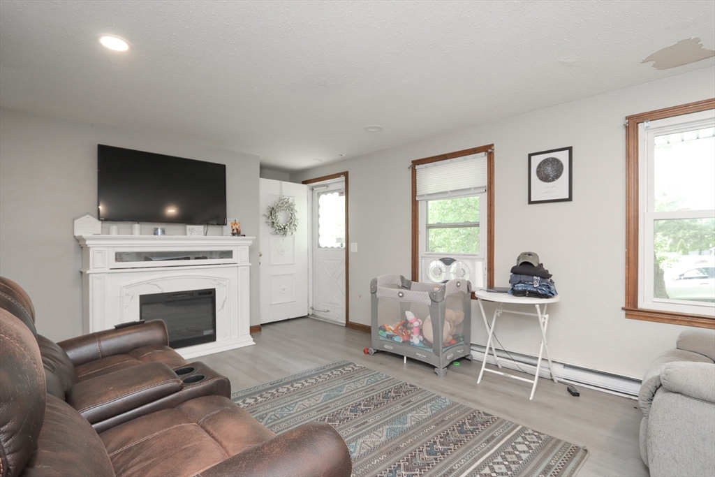 281 Bolton Street Springfield, MA 01119 - Photo 3 of 18 a living room with furniture a flat screen tv and a fireplace