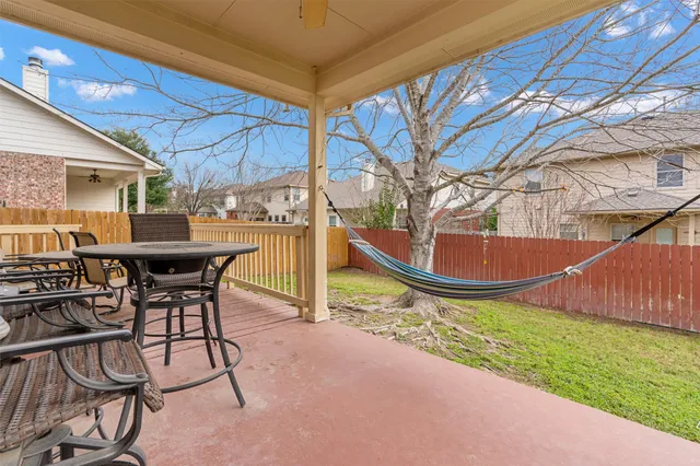 a view of a patio with table and chairs with wooden floor and fence