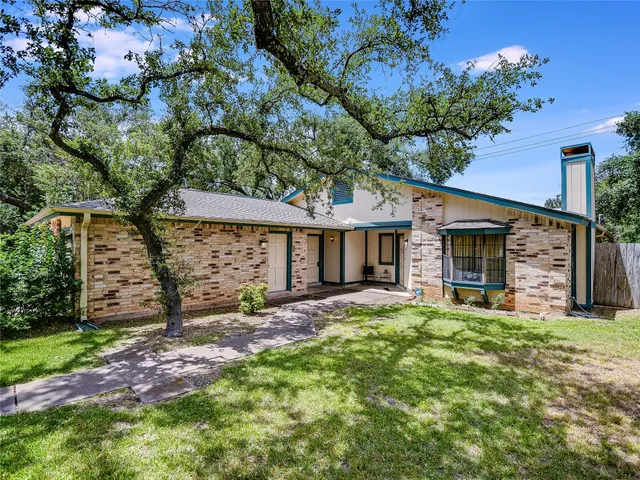 a view of a house with backyard and a tree