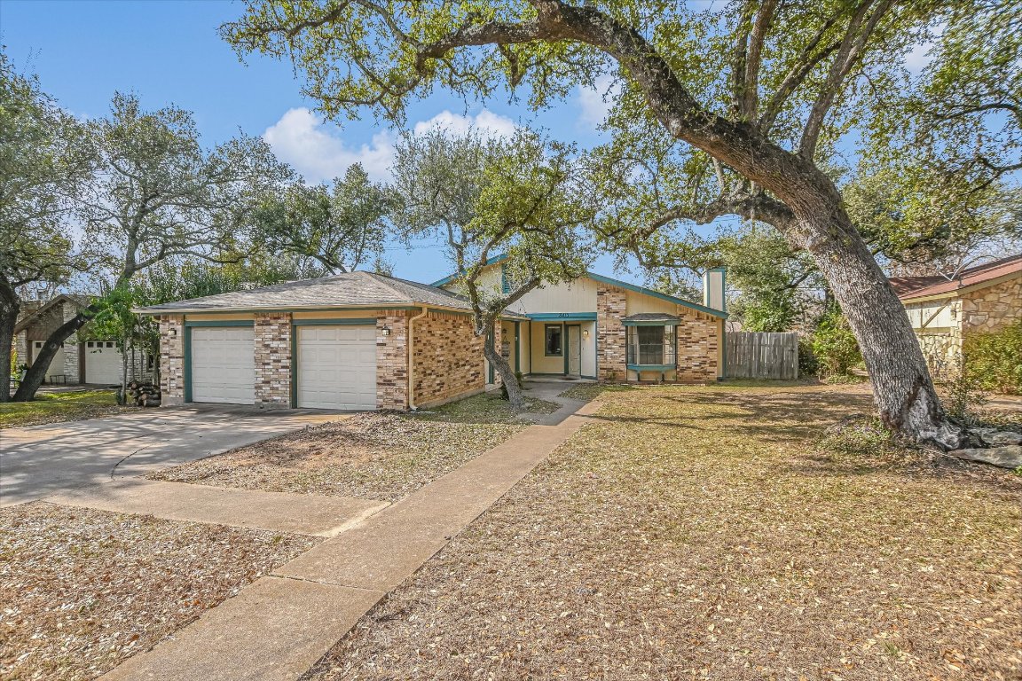 8415 Fathom Circle, Unit B Austin, TX 78750 - Photo 11 of 17 a front view of a house with a garden and trees