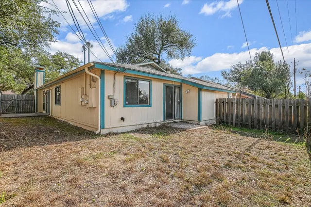 a front view of a house with a garden and trees