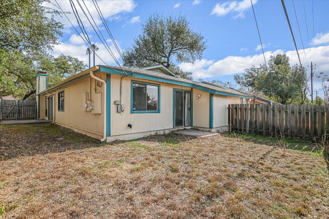 8415 Fathom Circle, Unit B Austin, TX 78750 - Photo 14 of 17 a view of a white house with a big yard and large trees with wooden fence