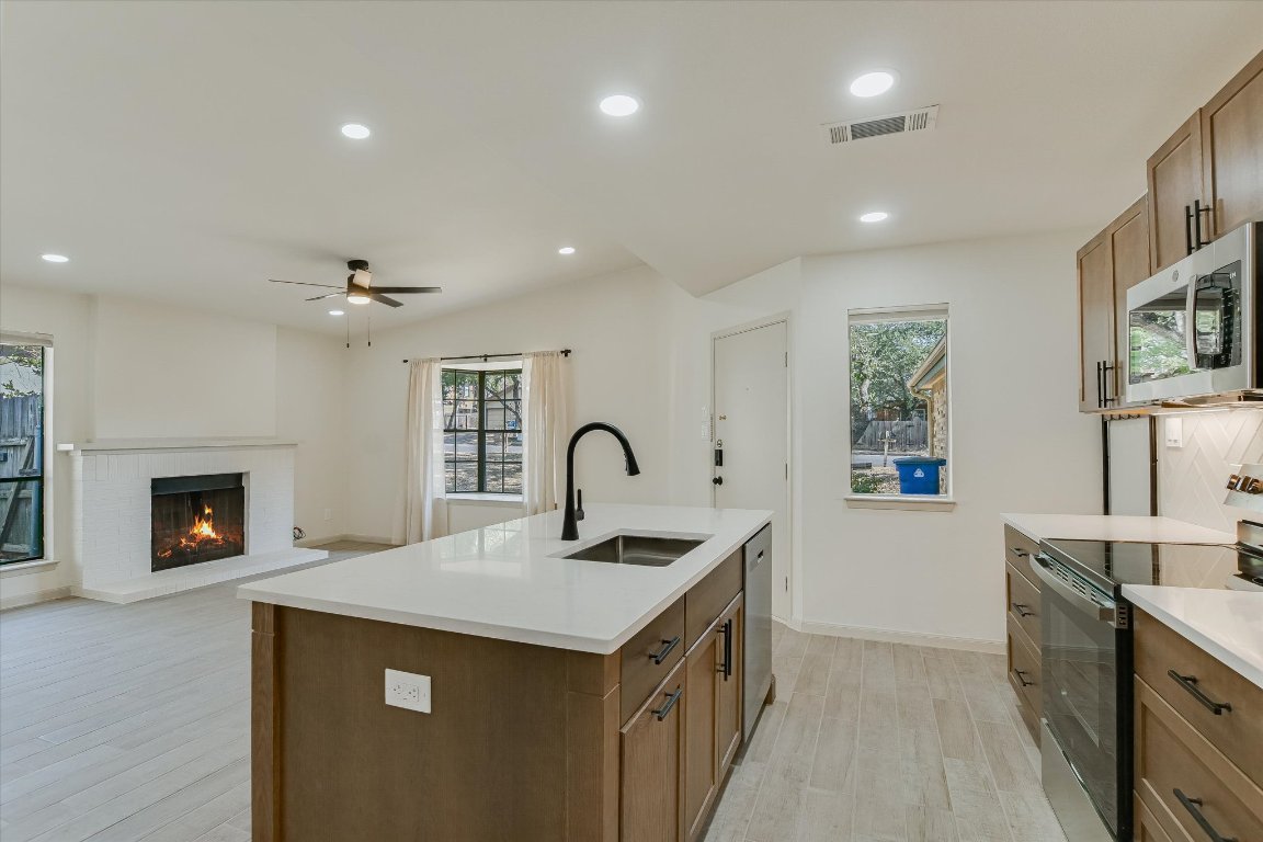 8415 Fathom Circle, Unit B Austin, TX 78750 - Photo 17 of 17 a kitchen with a sink and a stove top oven