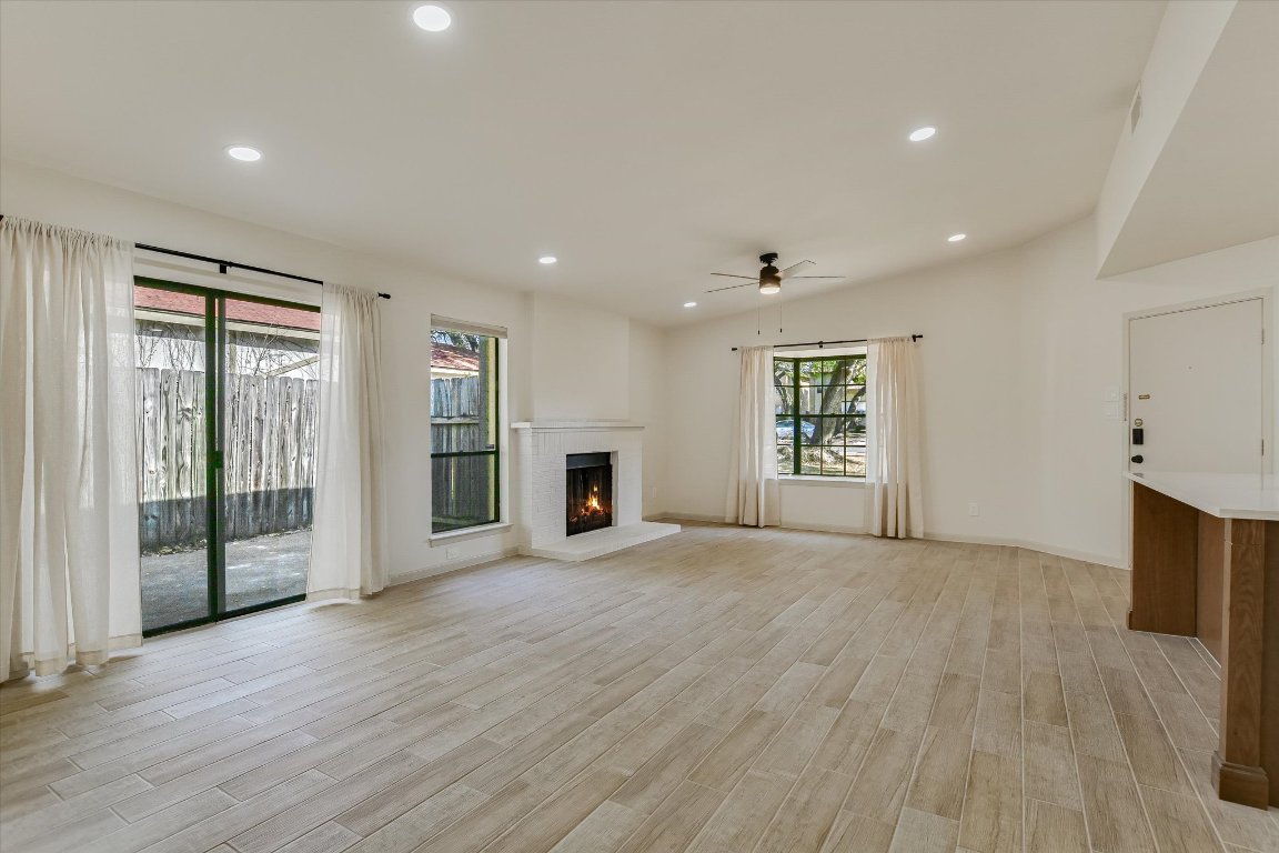 8415 Fathom Circle, Unit B Austin, TX 78750 - Photo 3 of 17 an empty room with wooden floor and windows