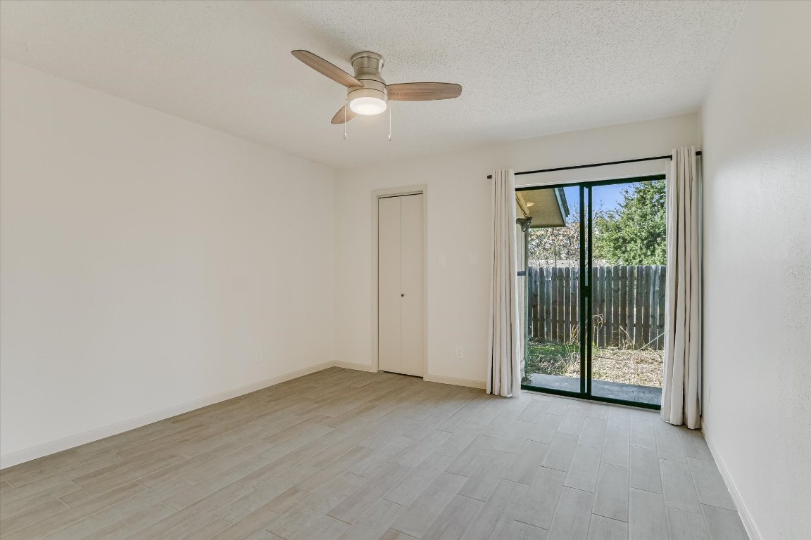 8415 Fathom Circle, Unit B Austin, TX 78750 - Photo 4 of 17 an empty room with wooden floor fan and windows