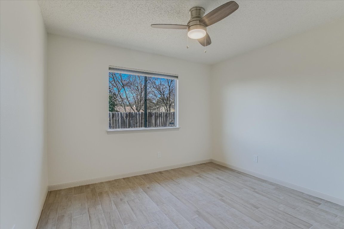 8415 Fathom Circle, Unit B Austin, TX 78750 - Photo 6 of 17 wooden floor in an empty room with a window
