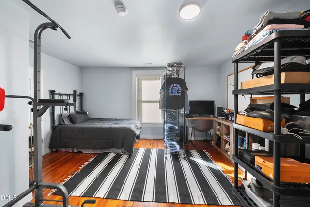 a living room with furniture a rug and gym equipment