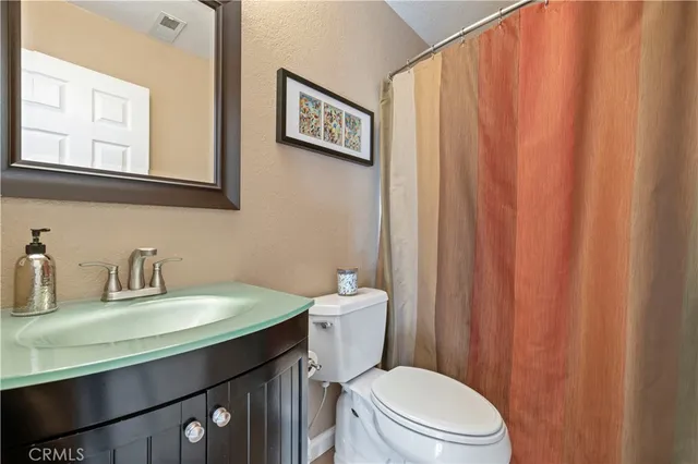 a bathroom with a granite countertop sink a toilet and bathtub