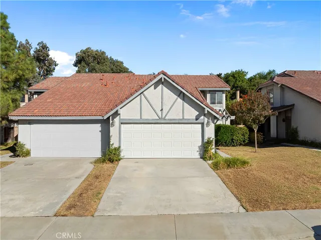 an aerial view of a house with a yard and mountain view in back