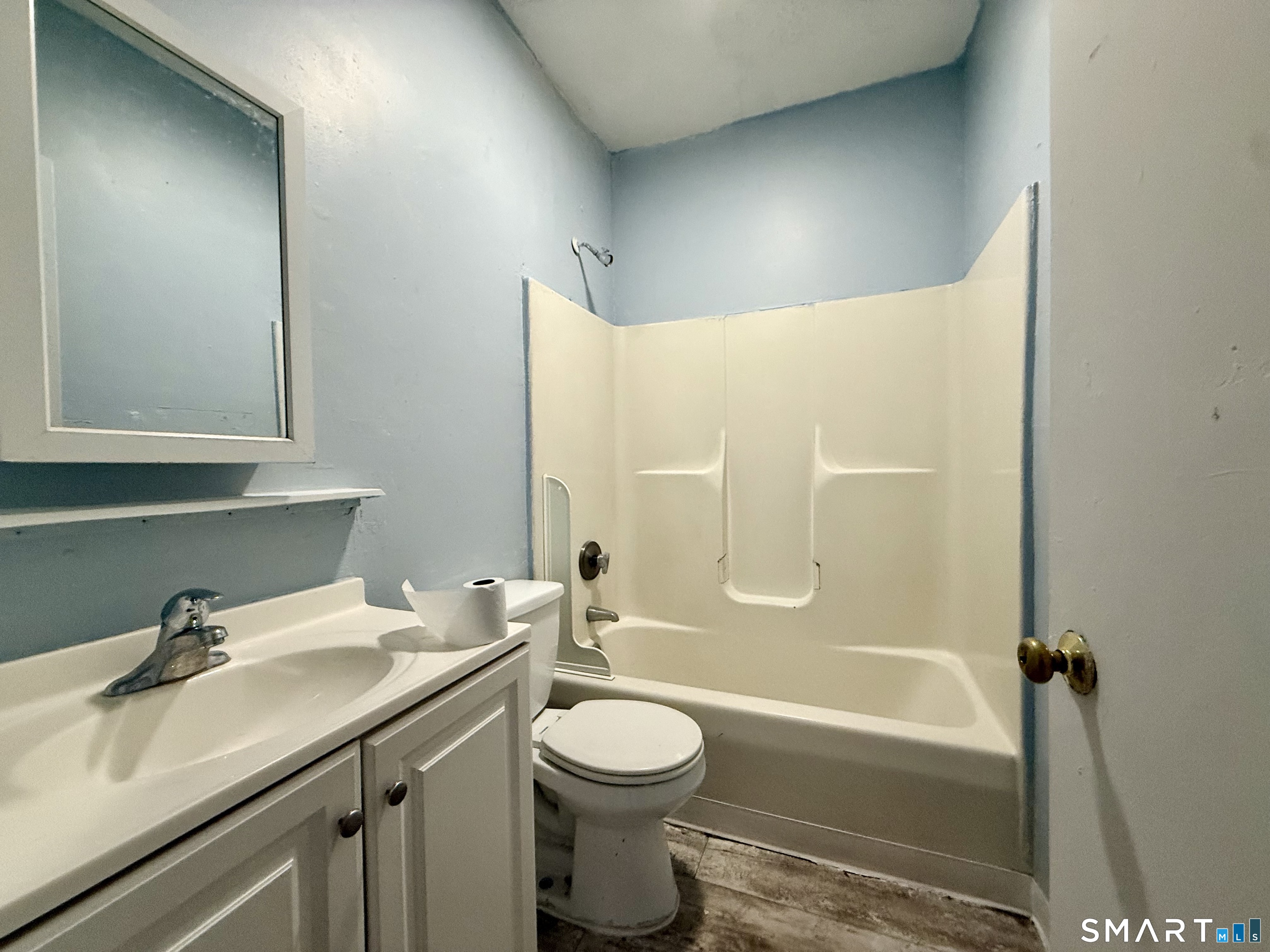a bathroom with a granite countertop sink toilet and shower