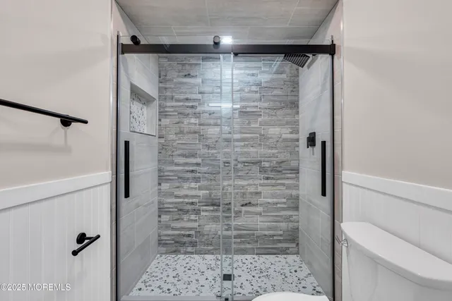 an empty room with wooden floor and a ceiling fan