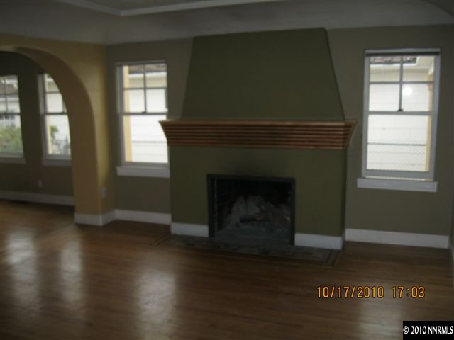 825 La Rue Avenue Reno, NV 89509 - Photo 3 of 13 an empty room with wooden floor fireplace and windows