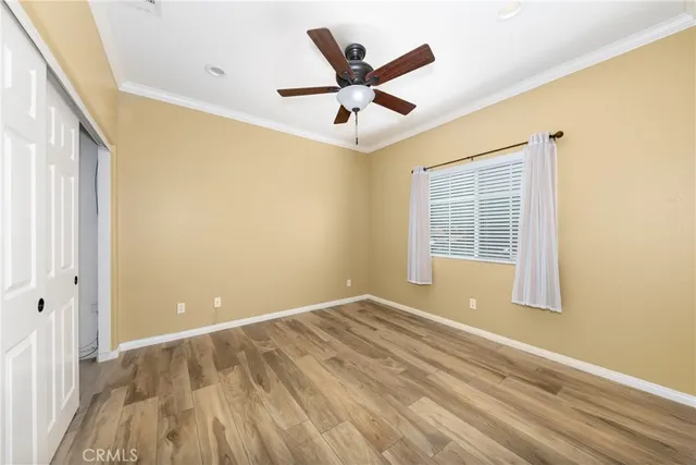 a view of a big room with wooden floor and a ceiling fan