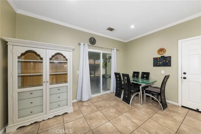 a kitchen with white cabinets a sink a stove a refrigerator and a dining table