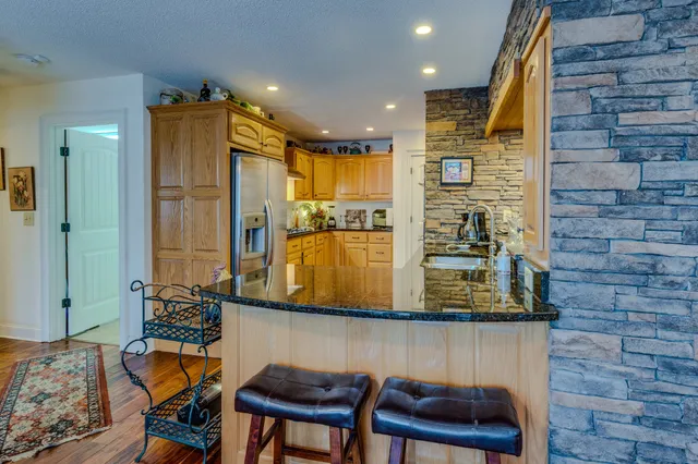 a kitchen with stainless steel appliances granite countertop a refrigerator and a sink