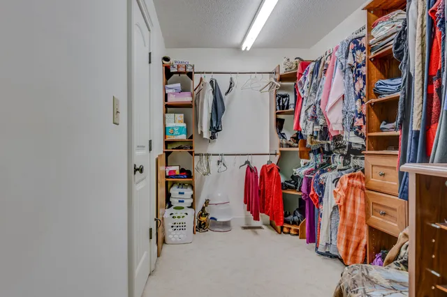 a bedroom with a bed a chandelier and dresser