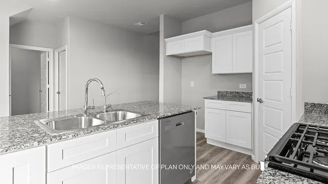 a kitchen with granite countertop a sink stove and cabinets