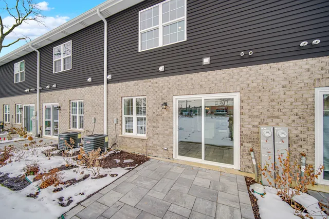 a view of a brick house with large windows