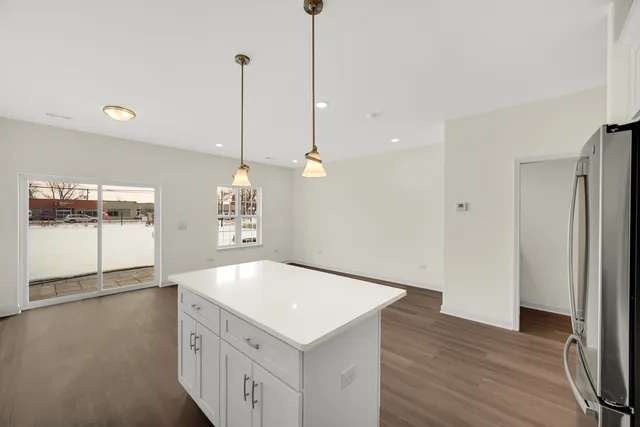 a kitchen with a sink a chandelier and wooden floor