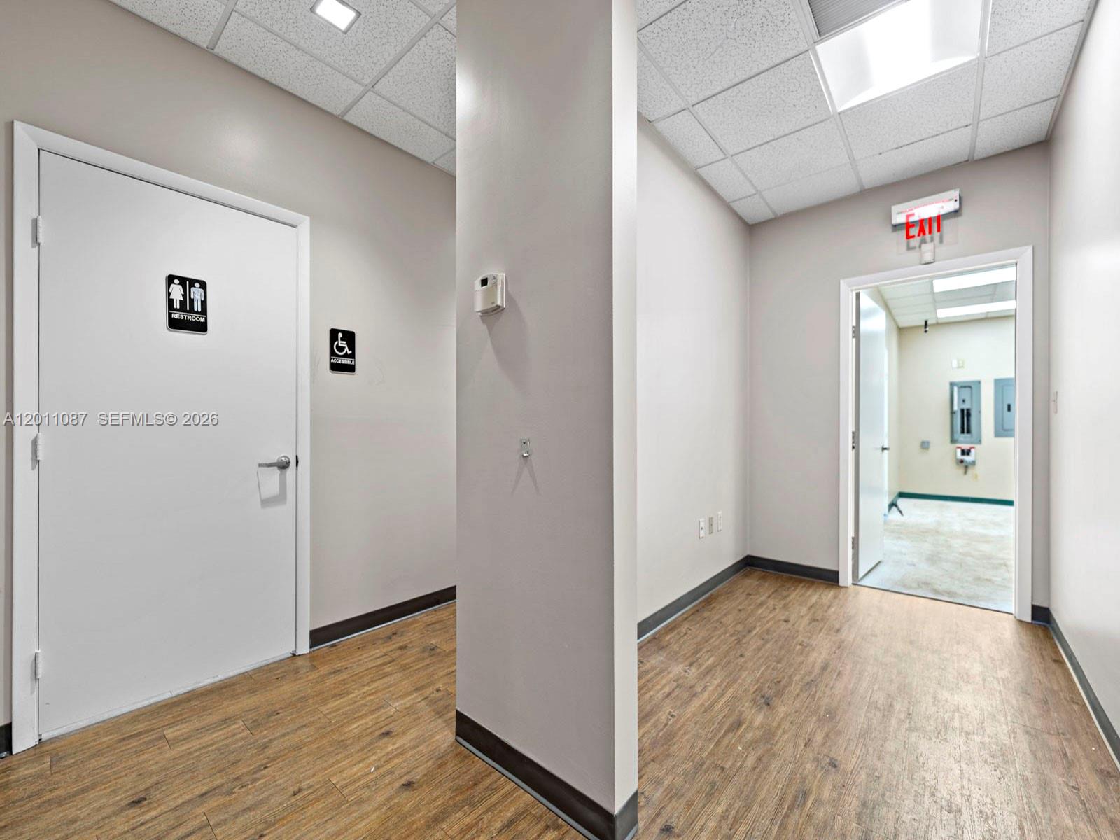 735 Shotgun Road Sunrise, FL 33326 - Photo 16 of 21 a view of a hallway with wooden floor and a bathroom