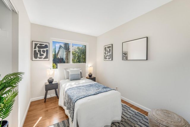a bedroom with a bed and a painting on the wall