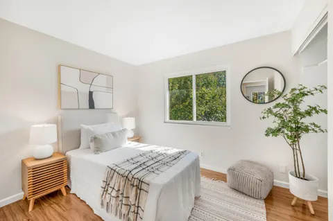 a bedroom with a bed and a potted plant