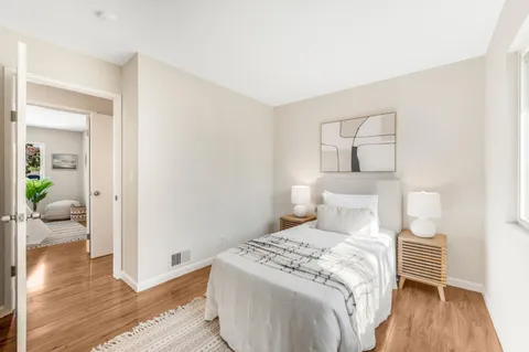 a bedroom with a bed and wooden floor