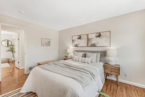 a bedroom with a bed and wooden floor