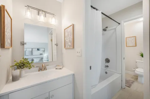a bathroom with a sink a large mirror a bathtub and shower