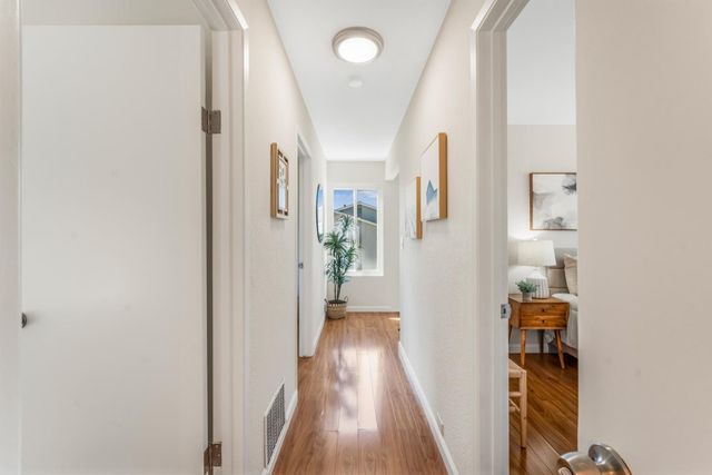 a view of a hallway with wooden floor and entryway