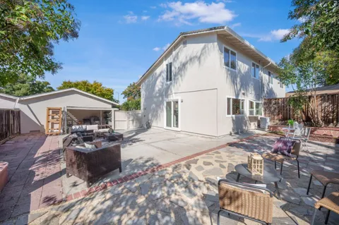 a view of a house with backyard and sitting area
