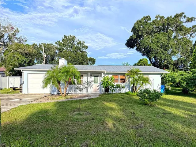 a view of a house with a yard and sitting area