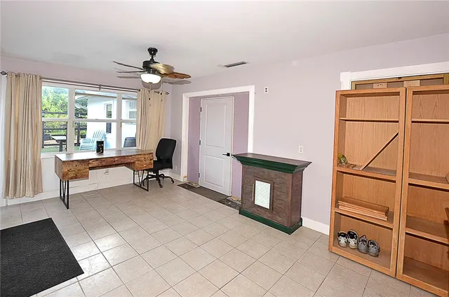 a view of a workspace with furniture and a window