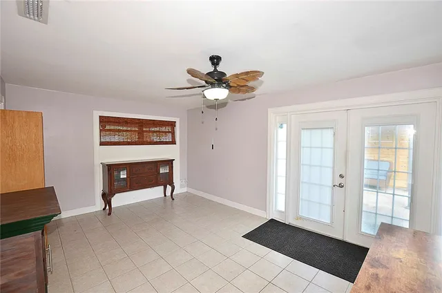 a view of an empty room with cabinet and a chandelier fan