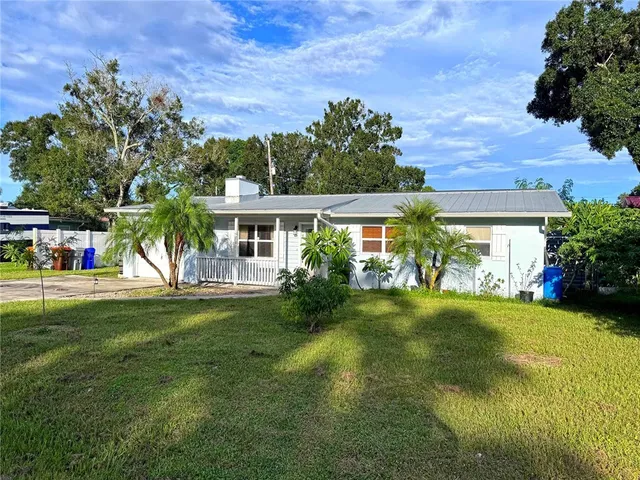 a view of a house with a big yard and a large tree