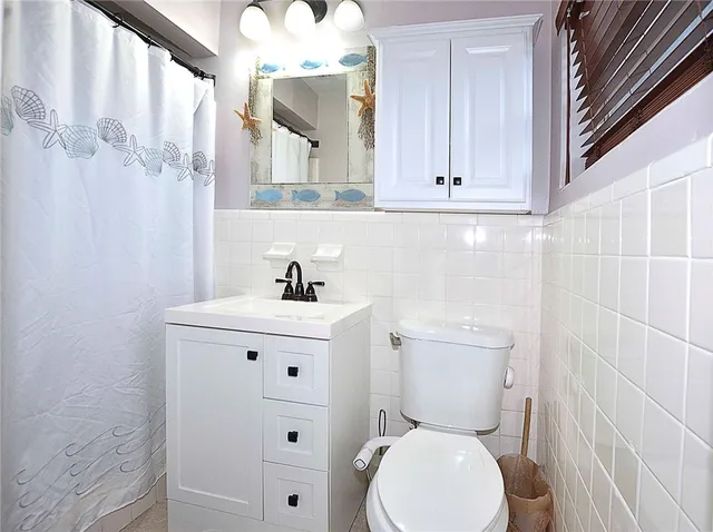 a white toilet sitting next to a bathroom sink