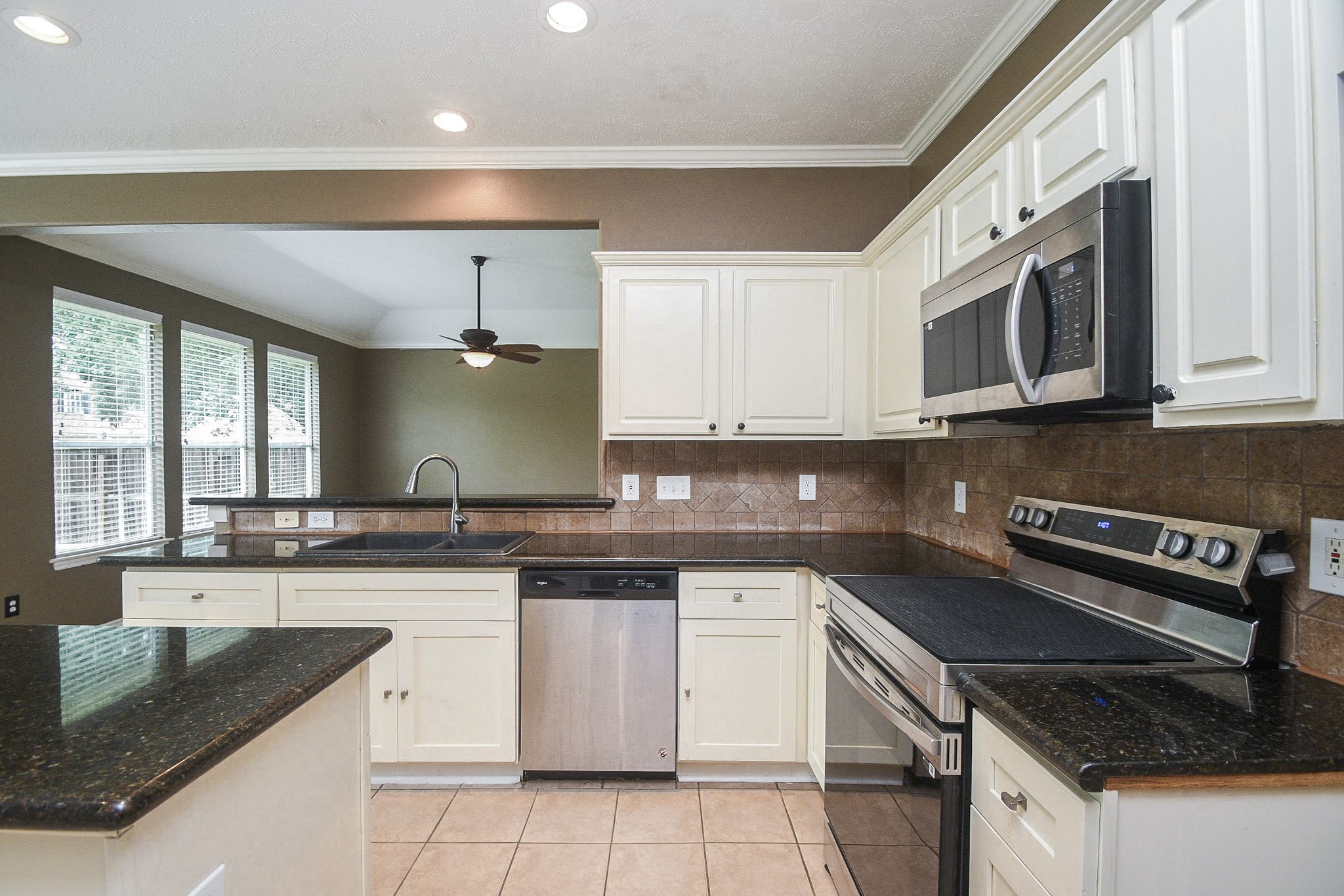 5602 Walkabout Way Katy, TX 77450 - Photo 6 of 33 a kitchen with stainless steel appliances granite countertop a sink stove and microwave