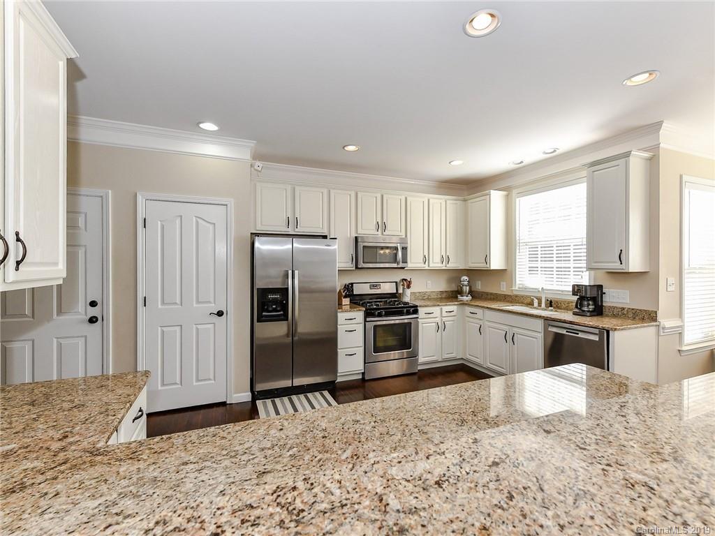 4723 Lapis Court Fort Mill, SC 29708 - Photo 11 of 36 a kitchen with granite countertop a refrigerator and a stove top oven