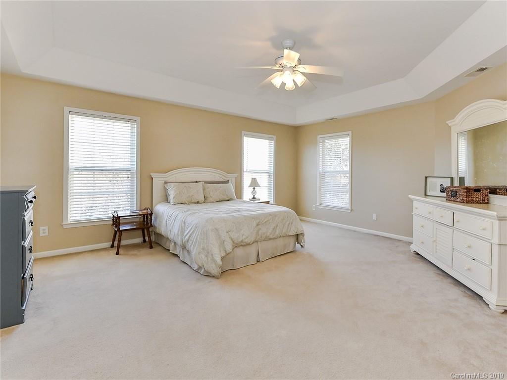 4723 Lapis Court Fort Mill, SC 29708 - Photo 18 of 36 a spacious bedroom with a bed and a chandelier