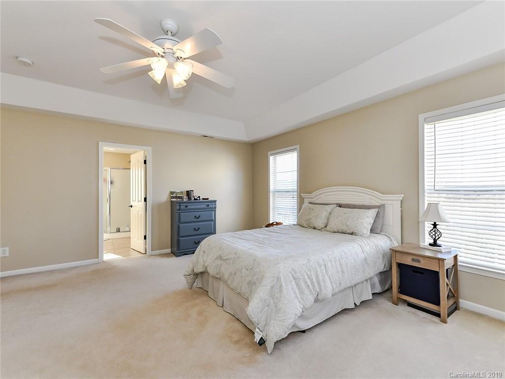 4723 Lapis Court Fort Mill, SC 29708 - Photo 19 of 36 a bedroom with a bed and a chandelier