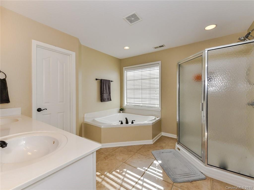 4723 Lapis Court Fort Mill, SC 29708 - Photo 20 of 36 a bathroom with a tub a sink a mirror and a shower
