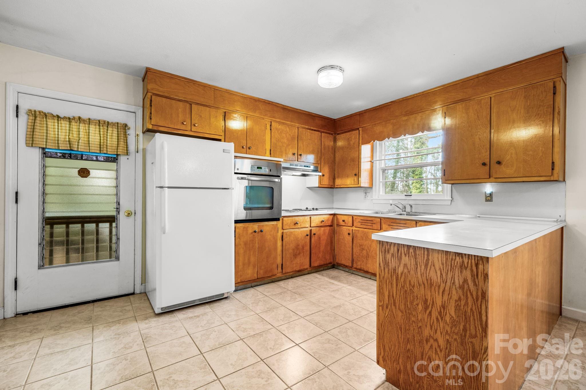 1200 Piedmont Road Morganton, NC 28655 - Photo 3 of 27 a kitchen with a refrigerator a sink and dishwasher