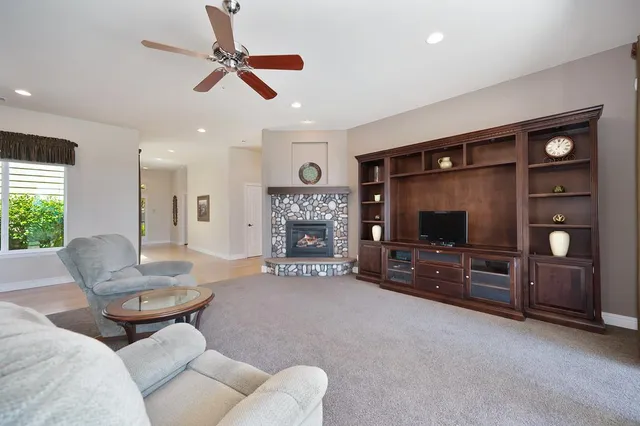 a living room with furniture a flat screen tv and a fireplace