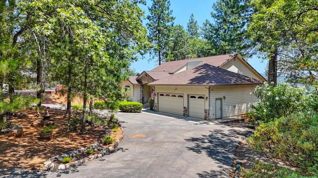 a aerial view of a house next to a big yard and large trees