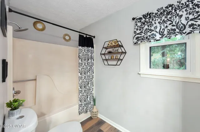 a bathroom with a shower curtain and a window