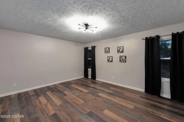 a view of an empty room with closet and a window